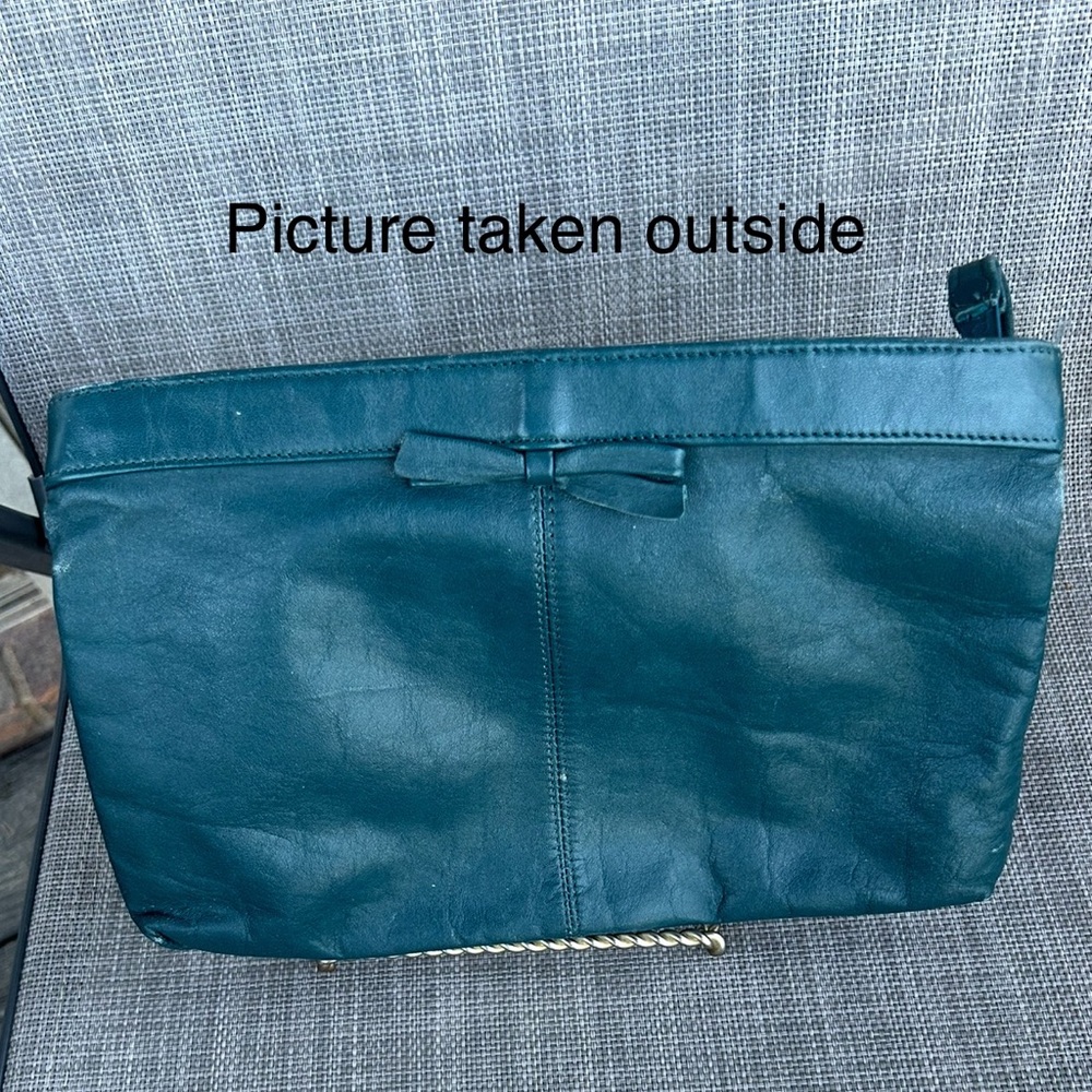 Teal or greenish blue Leather Clutch with Bow Detail and wrist strap.